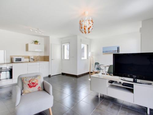 un salon avec une grande télévision et une chaise dans l'établissement Apartment Domaine d'Augustin Apt B01 by Interhome, à Saint-Malo
