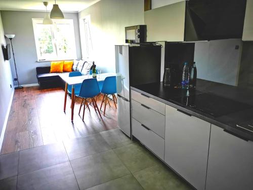 a kitchen with a black counter top and a table at Apartment Cyprys 1 in Oświęcim