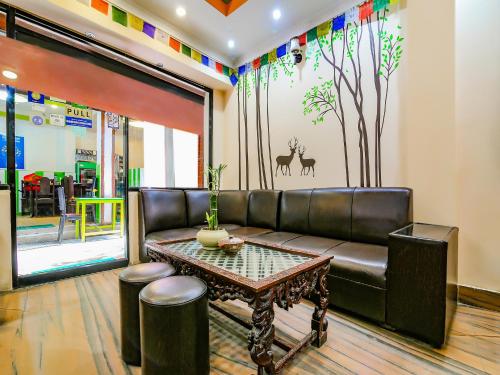 a living room with a leather couch and a table at Hotel Happy Home or Mudkhu Durbar in Kathmandu