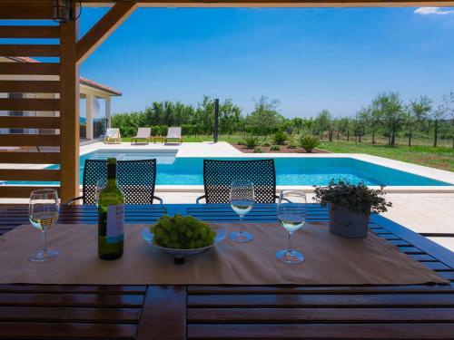 een tafel met wijnglazen en een kom druiven bij Holiday Home Eugen by Interhome in Barban