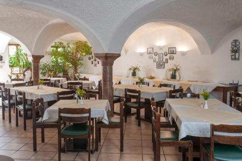 a restaurant with tables and chairs in a room at Pension Poschmühle in Traunreut