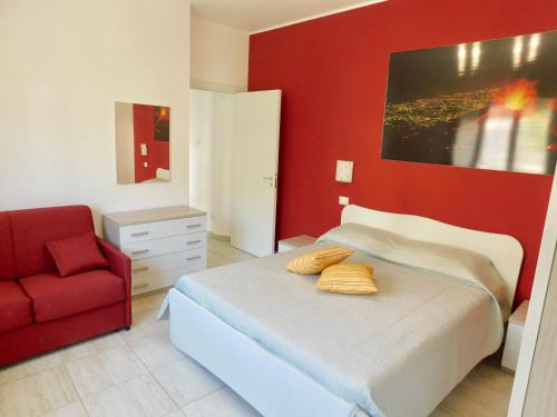 1 dormitorio con cama y pared roja en Vanilla Apartments, en Giardini Naxos