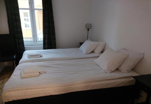 メレルードにあるMelleruds Golfklubb Bed & Breakfastのベッドルーム1室(白いシーツが備わるベッド2台、窓付)