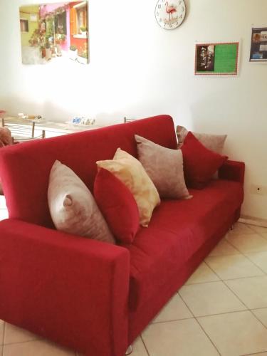 a red couch with a bunch of pillows on it at le terme sotto casa 2 free in Rapolano Terme