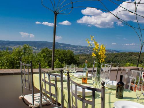 a table with wine bottles and chairs with a view at Villa Gaia by Interhome in Poggio Ferro