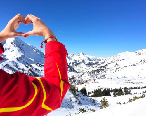 a person making a heart with their hands in the snow at Andi's Skihotel in Obertauern