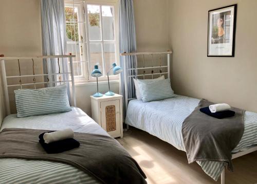 Un pat sau paturi într-o cameră la Quaint Seaside Cottage