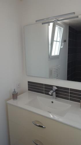 une salle de bain avec un lavabo blanc et un miroir dans l'établissement Maison de charme La Flotte en Ré, à La Flotte