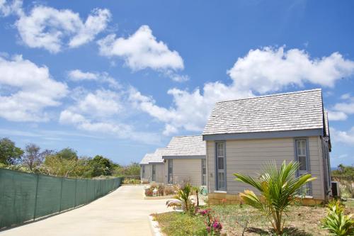 a house with a fence next to a driveway at West Rock Villas in Saint James