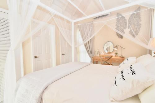 a bedroom with a white bed and a window at West Rock Villas in Saint James