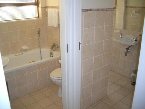a bathroom with a toilet and a tub and a sink at A Place in Thyme in Fish hoek