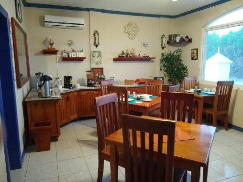 a dining room with wooden tables and chairs at Drake Inn in Puerto Villamil