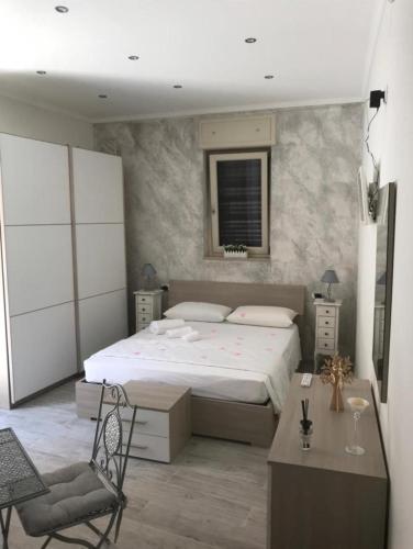 um quarto com uma cama, uma secretária e uma cadeira em La Maison - matrimoniale em Stornara