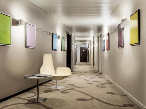 a hallway with a chair and paintings on the walls at Starling Hotel Lausanne in Lausanne