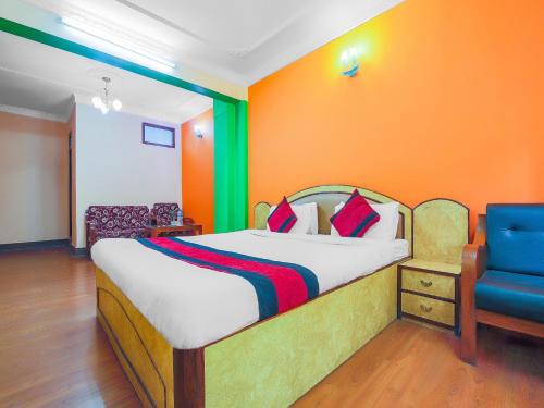 a bedroom with a bed and a blue chair at Hotel Happy Home or Mudkhu Durbar in Kathmandu