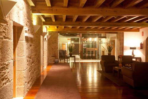 a living room with a stone wall and wooden ceiling at San Francisco Hotel Monumento in Santiago de Compostela