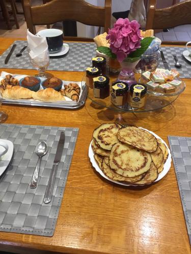 une table en bois avec des assiettes de nourriture sur une table dans l'établissement Chambres d'hôtes Chez Coco, à Saint-Georges-de-Reneins