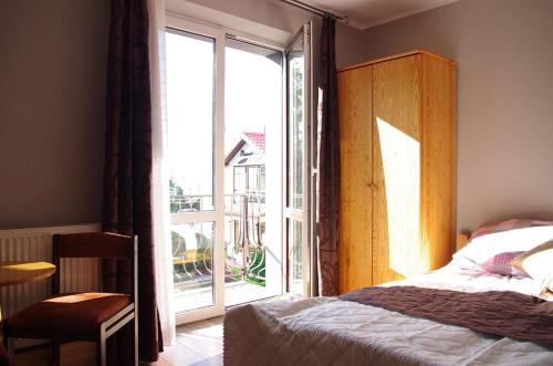 a bedroom with a bed and a large window at Pokoje gościnne U Jadzi in Chałupy