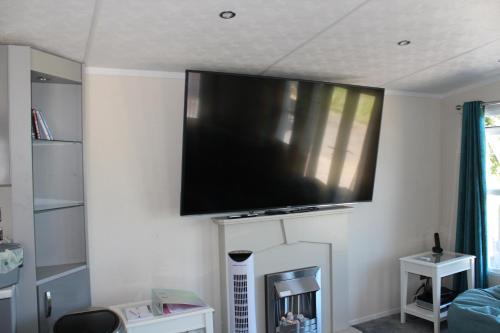 a flat screen tv on the wall of a living room at Molland Manor House Bed & Breakfast in Sandwich