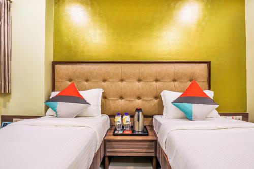 two beds sitting next to each other in a room at FabHotel Landmark Residency - Nr MIDC Turbhe in Navi Mumbai