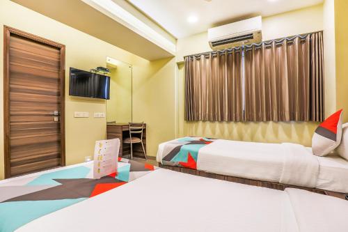a hotel room with two beds and a tv at FabHotel Landmark Residency - Nr MIDC Turbhe in Navi Mumbai