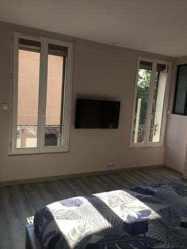 1 dormitorio con 1 cama y TV de pantalla plana en La maison parisienne maison deux pièces à louer au pied du métro en Maisons-Alfort