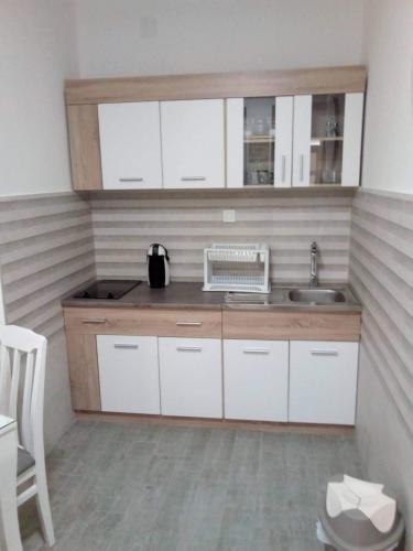 a small kitchen with white cabinets and a sink at Tara Deluxe Apartment in Budva