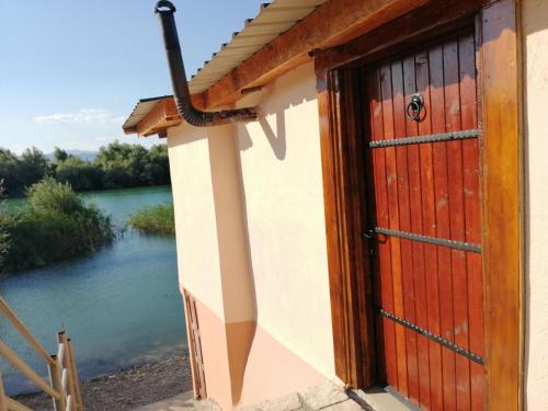a door to a house with a view of a river at Skadar Lake House Virpazar in Virpazar