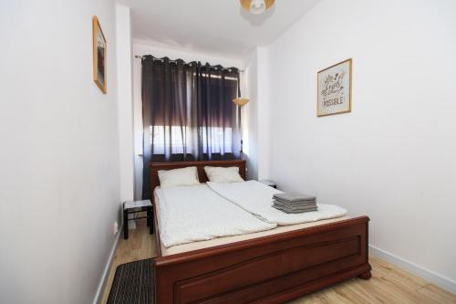Dormitorio pequeño con cama y ventana en Green Kabaty Apartment 3, en Varsovia