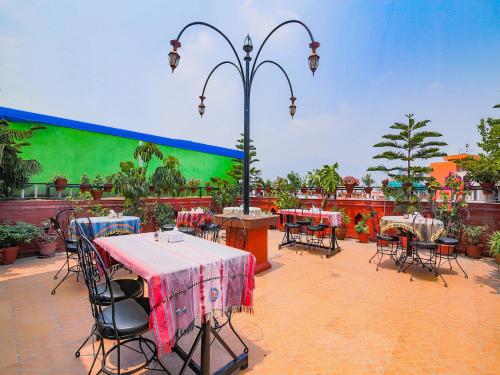 a patio with tables and chairs and a green wall at Hotel Happy Home or Mudkhu Durbar in Kathmandu