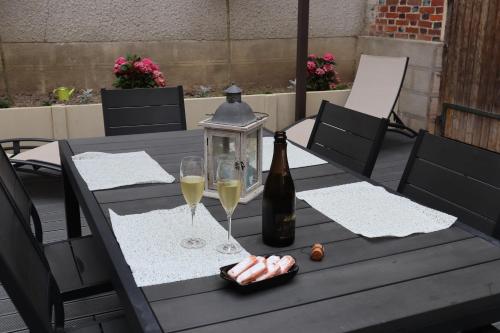 a table with a bottle of wine and two glasses at LA GOUTTE D'OR in Avize