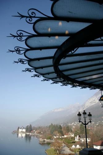 a view of a lake from under a roof at Le Palace De Menthon in Menthon-Saint-Bernard