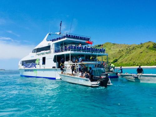 a boat in the water with people on it at Malakati Village Beach House in Nacula Island