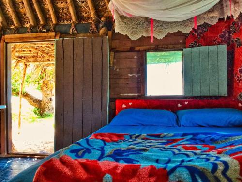 a bed in a room with a window and a bed sidx sidx sidx at Malakati Village Beach House in Nacula Island