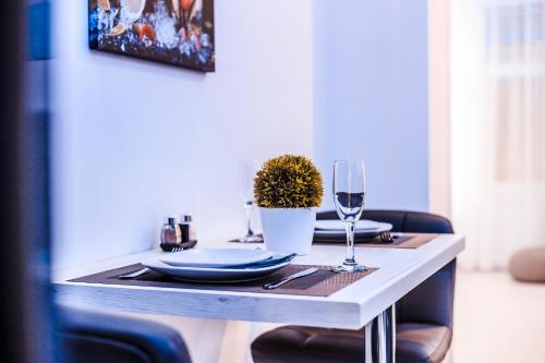 a table with plates and wine glasses on it at Luxury Smart Apartments in Szeged