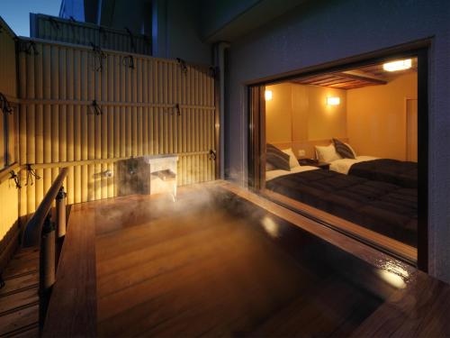a living room with a bed and a large window at Asaya in Nikko