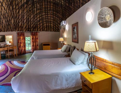 Un pat sau paturi într-o cameră la Gooderson DumaZulu Lodge