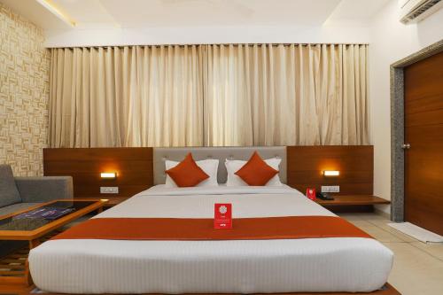 a bedroom with a large bed and a couch at Hotel Avista in Vadodara