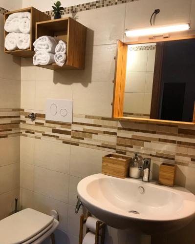 a bathroom with a sink and a toilet and a mirror at LA PERGOLA - Affitta Camere in Santa Lucia del Mela