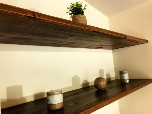 a wooden shelf with a plant on a wall at LA PERGOLA - Affitta Camere in Santa Lucia del Mela