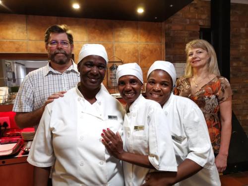 a group of chefs posing for a picture in a kitchen at De Oude Herberg in Centurion