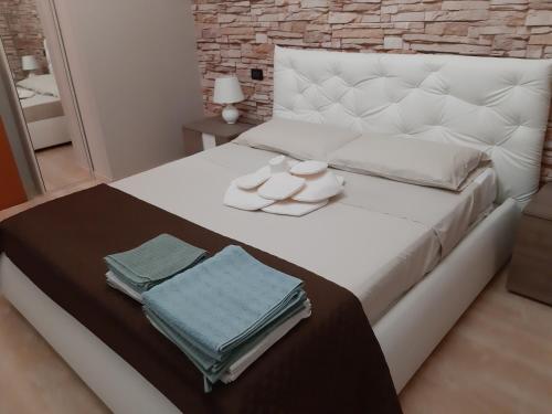 a bedroom with a white bed with towels on it at Casarelax in Abano Terme