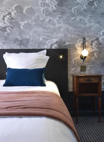 a bedroom with a bed with a blue pillow and a nightstand at Le Palace De Menthon in Menthon-Saint-Bernard