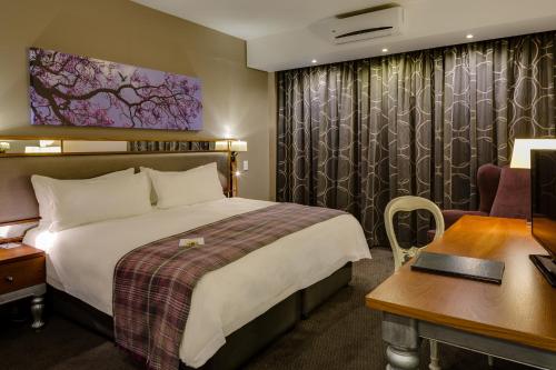 a bedroom with a large bed and a large window at ANEW Hotel Hatfield Pretoria in Pretoria
