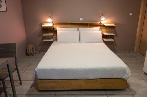 a bedroom with a large bed with white sheets at Marion Apartments in Kourouta