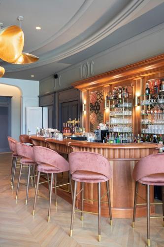 a bar with pink chairs in a restaurant at Le Palace De Menthon in Menthon-Saint-Bernard