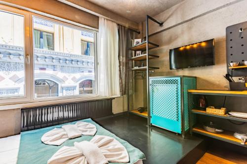 Habitación con cama, TV y ventanas. en Mansion Gorki en Estambul