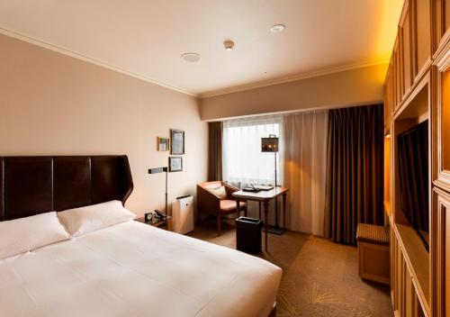 a hotel room with a bed and a desk at Royal Park Hotel Takamatsu in Takamatsu