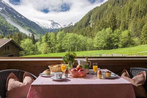 a table with a bowl of fruit and a view of mountains at Mehlerhof in Tux