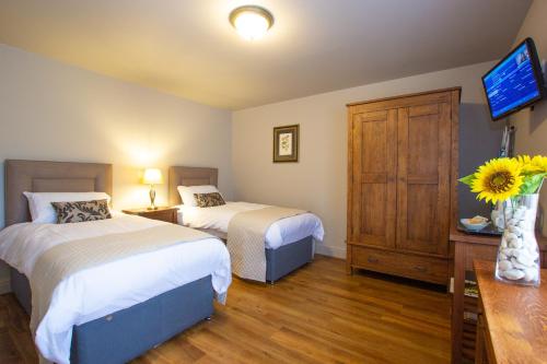 um quarto de hotel com duas camas e uma televisão em The Cherry Tree Rochford em Rochford